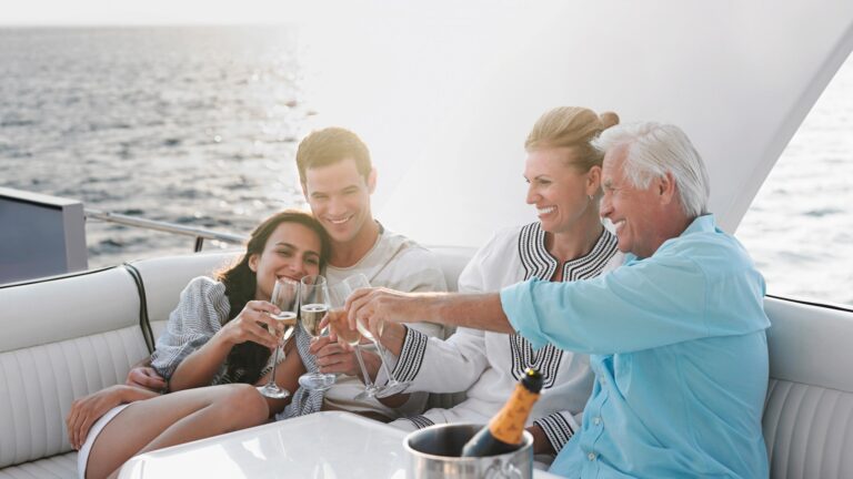 A family enjoing their holiday on a yacht with the dad thinking about the financial habits he installed in himself that helped with his wealth building